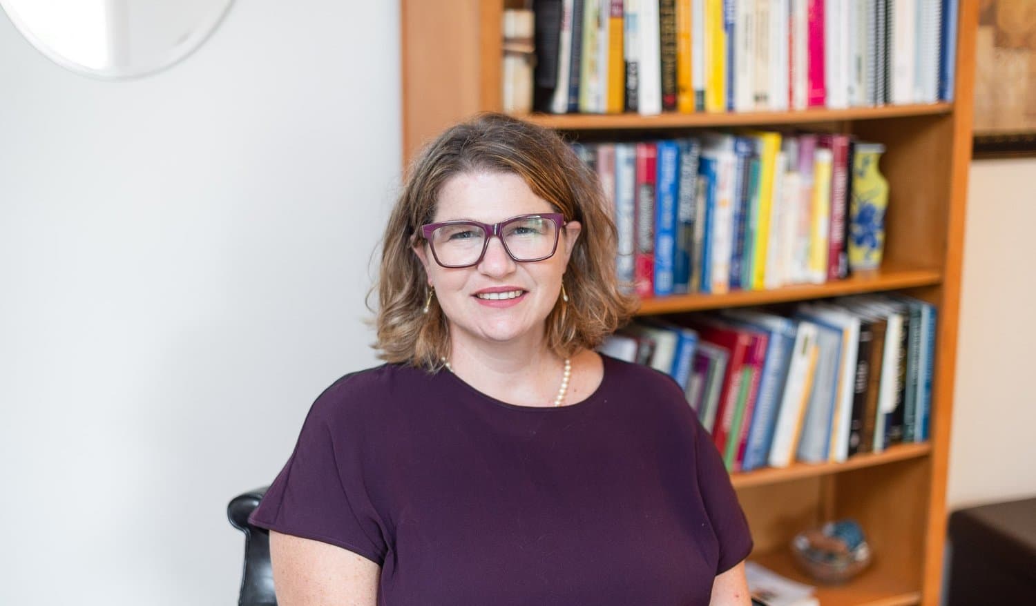 Elisabeth Coffey at the bookshelf in her Florham Park office